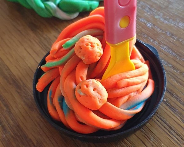 Knete-Spaghetti mit Bällchen in einer kleinen Pfanne